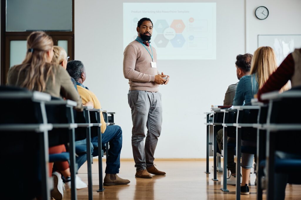 Black adult education teacher giving presentation in the classroom.